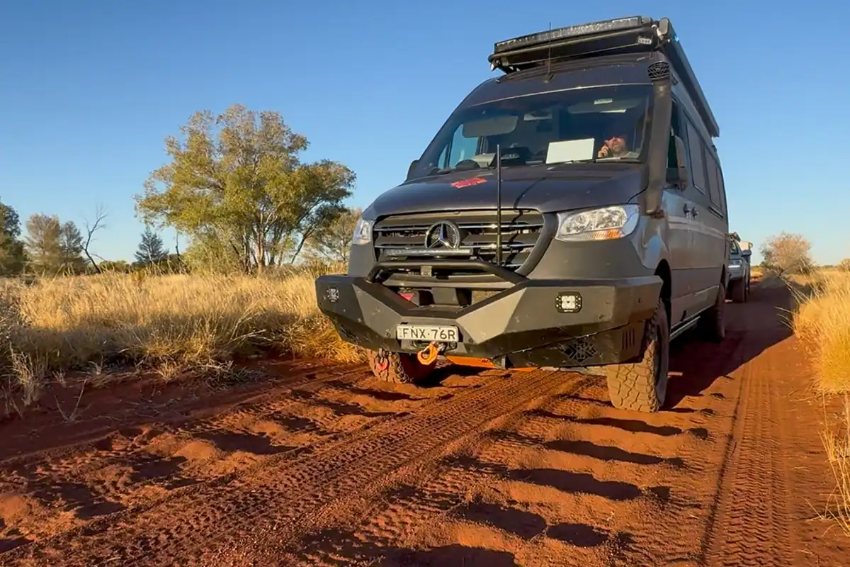 Kimberley Kampers offroad motorhome driving on a heavily corrugated red dirt road in the Australian outback desert, showcasing its heavy-duty suspension and off-road capability.